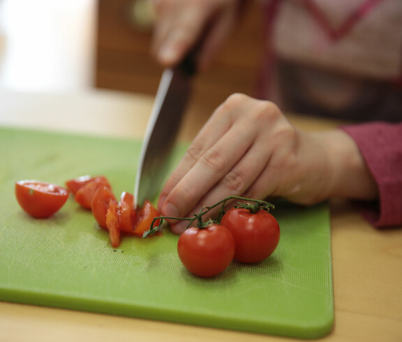 Tomaten werden mit einem Messer kleingeschnitten