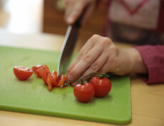 Tomaten werden mit einem Messer kleingeschnitten