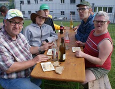 Sechs  Menschen sitzen an einem Tisch.