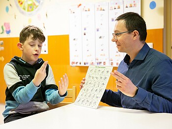 Luan und Hortleiter Wolfgang Holzinger beim Fingeralphabet. Eines der Interessen des Neunjährigen. 