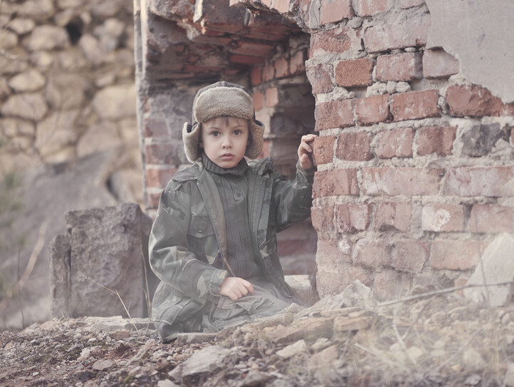 Child and  war. Poor, homeless child in the ruins of a destroyed house.